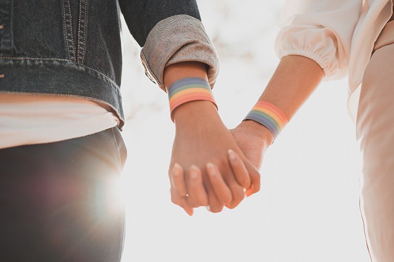 An LGBTQ couple holds hands.